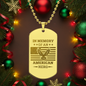 Gold dog tag pendant with 'In Memory of an American Hero' text and eagle design, surrounded by Christmas decorations.