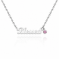 A silver affirmation necklace spelling 'Blessed' with a small round pink gemstone accent, shown on a white background with a soft reflection below.